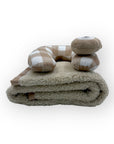 Folded blanket with checkered pillow on a white background