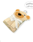 Folded beige blanket with teddy bear face design and 'Mother's Choice' tag on a white background