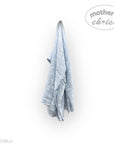 Blue towel hanging on a white wall with 'mother's choice' branding.