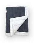 Knitted blanket with dark gray exterior and white interior on a white background