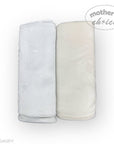 Two folded towels, one white and one beige, on a white background with 'Mother's Choice' branding.