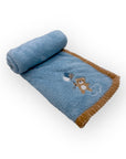 Blue baby blanket with teddy bear design on a white background