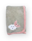 Gray blanket with pink edge and cloud and moon appliqués on a white background