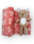 Plush toy bear with a pink floral blanket on a white background