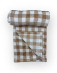 Folded brown and white checkered blanket on a white background