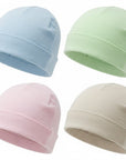 Four baby hats in blue, green, pink, and beige on a white background