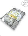 Baby booties with yellow and white pattern on a wooden surface, branded 'Mother's Choice'.