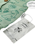 Green children's jacket with dinosaur patterns and 'mother's choice' tag on a white background