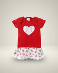 Red baby dress with a white heart design on a beige background