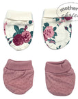 Two floral baby booties and two pink baby booties with polka dots on a white background.