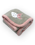 Folded blanket with cloud and moon design on a white background