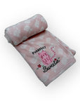 Pink blanket with cat design and text on a white background