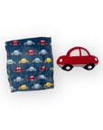 Folding towel with car pattern next to a red toy car on a white background
