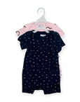 Navy baby romper with white polka dots on a hanger against a white background