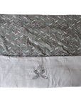 Patterned fabric with a white border and embroidered design on a white background