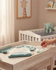 Stork And Baby light blue and cream baby boys romper with bear print and matching socks on a changing table.