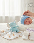 Stork And Baby blue striped knit baby hat on sleeping infant, with plush elephant and giraffe print blanket.