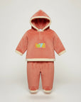 Stork And Baby coral fleece tracksuit with "Love" embroidery and cream trim. Cozy hooded set for girls.