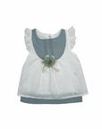 Stork And Baby white cotton linen dress with blue accents and a green flower embellishment. Features eyelet fabric and ruffled sleeves.