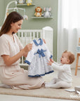 Stork And Baby white and blue floral baby dress with bow detail, perfect for special occasions.