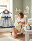 Stork And Baby white and blue floral baby dress with denim collar and trim, bow accent