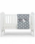 Stork And Baby Mother's Choice grey fleece baby receiver blanket with white chevron pattern draped on a white crib.