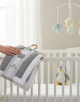 Stork And Baby grey sherpa fleece baby blanket with white trim, 75x100cm, on a hanger.