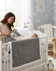 Stork And Baby grey sherpa fleece blanket with white trim, featuring a ribbed texture and a cute bear applique.