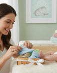 Stork And Baby pastel 100% cotton booties in a basket with a mother and baby.