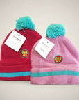 Stork And Baby pink and red knit infant winter hats with turquoise pom-poms and butterfly embroidery. Two pack.