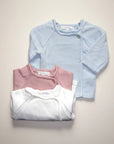 Stork And Baby assorted pastel baby cardigans in light blue, pink, and white. Soft knit, button front, perfect for layering.