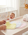 Stork and Baby infants check bibs in yellow, blue, and pink with white lace trim and PVC backing for feeding.