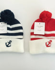 Stork And Baby Infants winter hat in navy and red stripes with white cuff and anchor embroidery. Features a pom-pom.