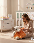 Stork and Baby orange infant girls dress set with a playful pattern, shown on a stuffed elephant.