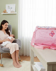 Stork And Baby pink square diaper bag with butterfly embroidery and floral print top. Includes changing mat.