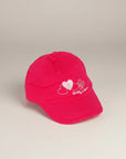 Stork And Baby pink cotton cap with embroidered hearts and "Hugs & Kisses" text for girls.