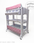 Stork And Baby pink and white baby bath caddy with star pattern, storage shelves, and wheels on a white background