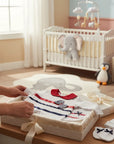 Stork And Baby 4-piece sailor girl starter pack in 100% combed cotton. Includes babygrow, hat, mittens, and bib.