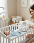 Stork And Baby Mothers Choice plush sheep toy and coral fleece blanket set in a nursery with a sleeping baby