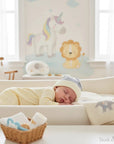 Stork And Baby striped knit baby hat in blue and white, worn by a sleeping baby.