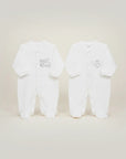 Stork And Baby white cotton footed pajamas with silver train and heart embroidery. 6-9 months.