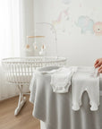 Stork And Baby white preemie 3-piece set including a bodysuit and footed pants made of soft cotton.