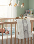 Stork And Baby white sherpa fleece baby blanket with ribbed texture and a bear emblem, 75x100cm.
