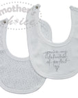 Two white baby bibs with text on a white background