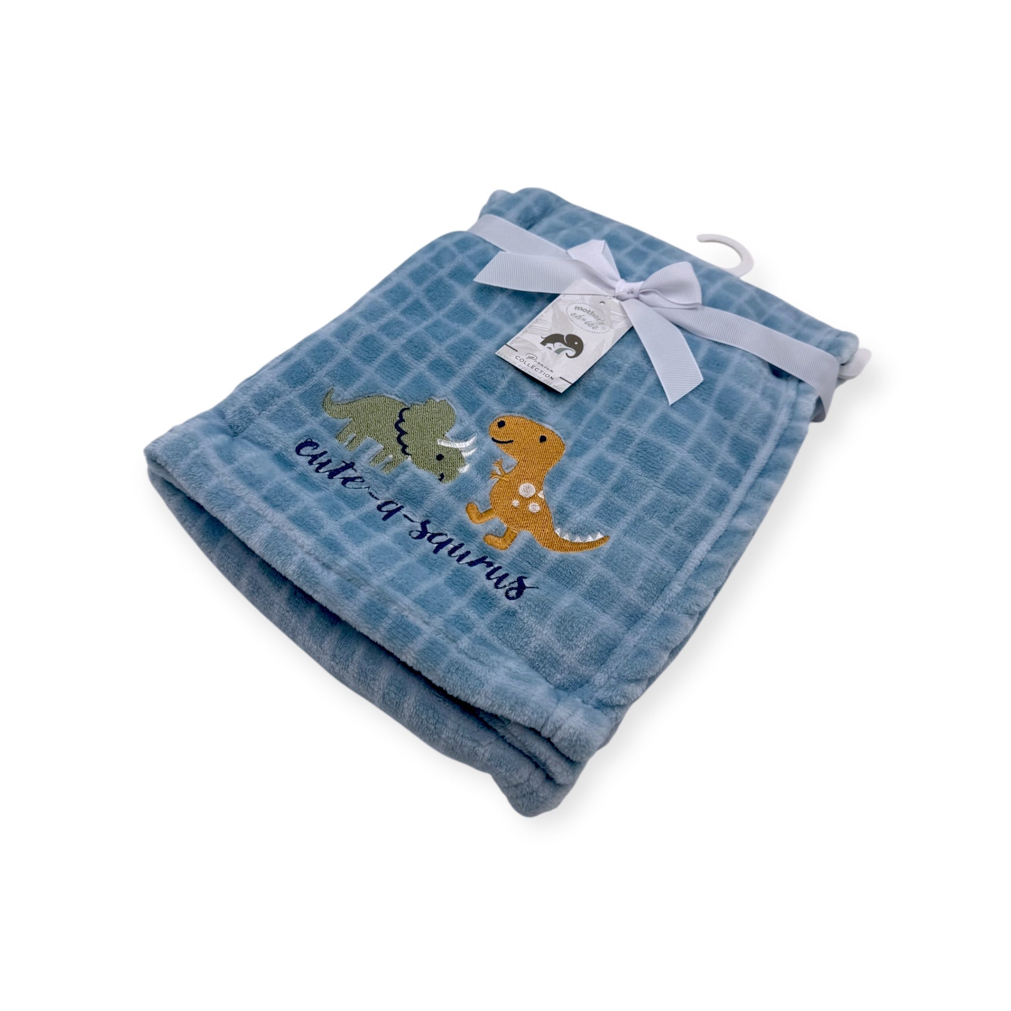 Blue baby blanket with dinosaur designs and a tag on a white background