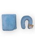 Blue towel and blue neck pillow with teddy bear design on a white background