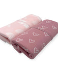 Two folded blankets with heart patterns on a white background