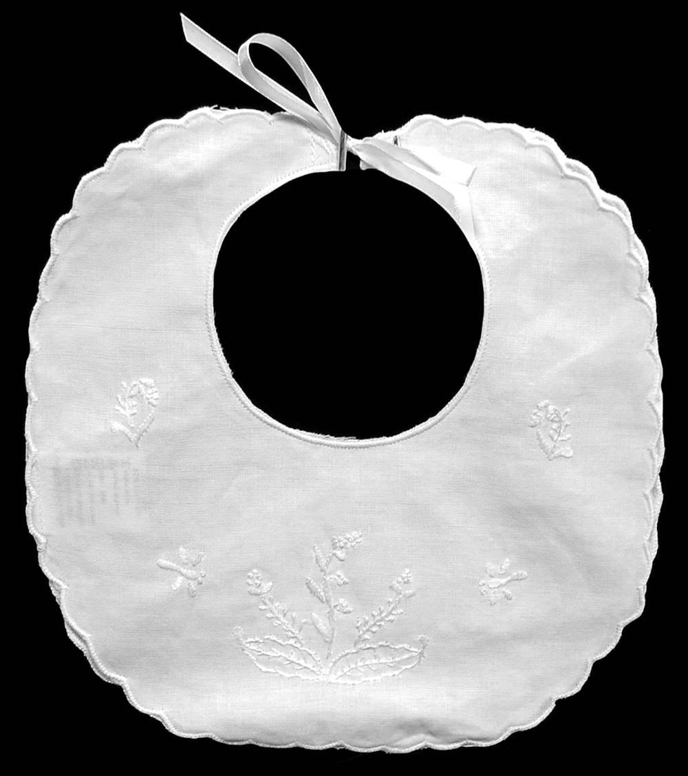 White baby bib with floral embroidery on a black background