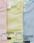 Packaged baby vests in pink, yellow, blue, and green with labels indicating size and material.