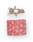 Floral-patterned pink blanket with a small plush toy on a white background